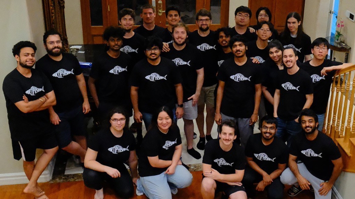 The team of Shellphish doctoral students pose at the bottom of a staircase.