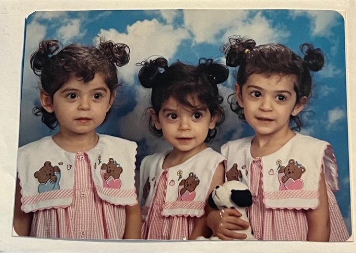 Photo of three young girl triplets in red and white dresses