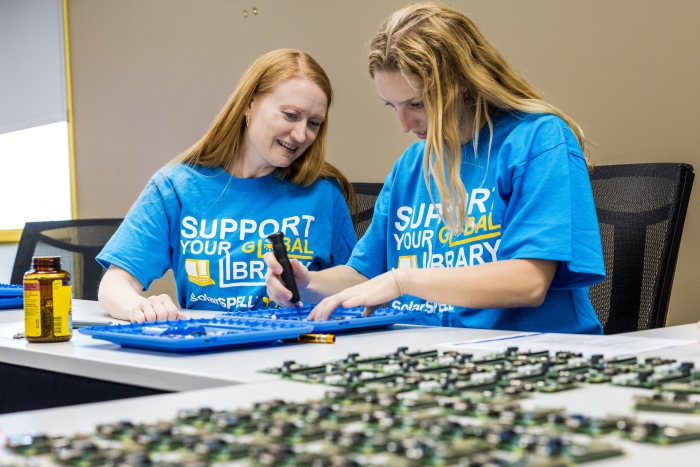 Two women build computer devices