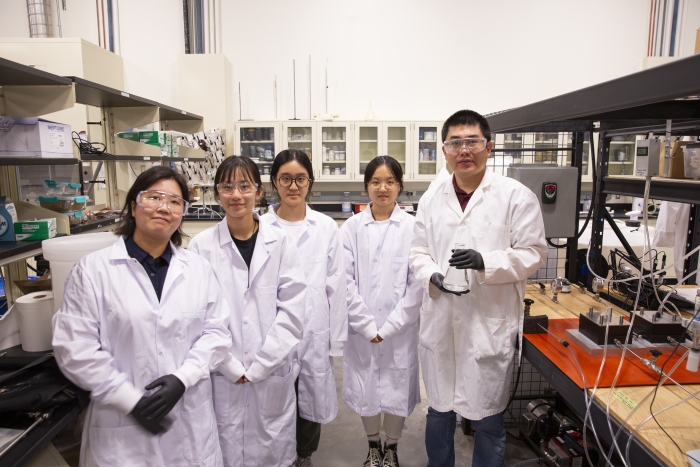 Researchers posing for a group photo in a lab.