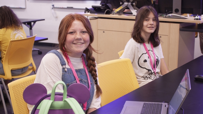 Two girls sit together at a table.