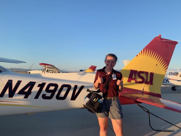 Photo of Audrey Schlichting on tarmac with ASU plane