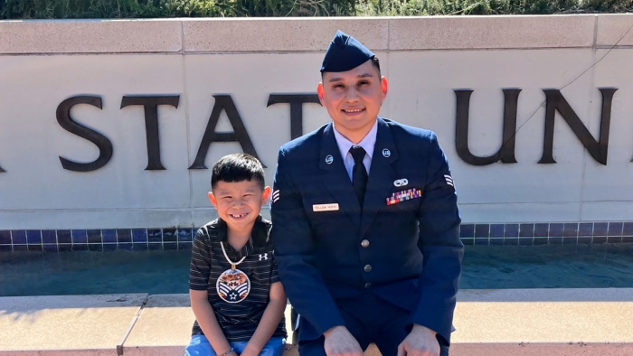 Man in military uniform poses with son on ASU campus