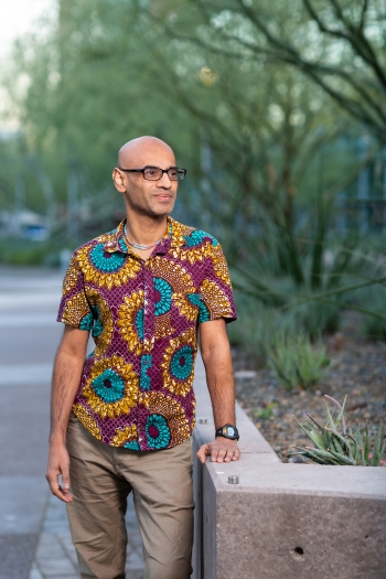 Photo of Dr. Arvind Varsani wearing a maroon shirt with gold and teal flowers