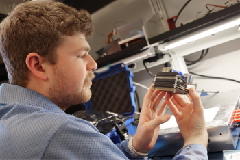 ASU student looks at cubesat instrumentation in a lab setting
