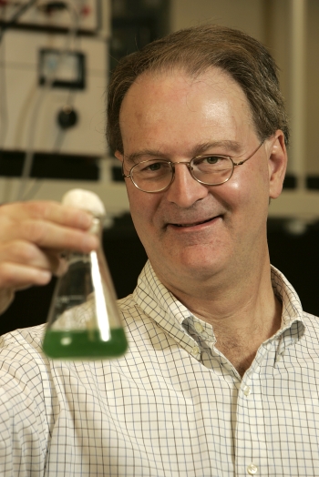 Man holding beaker with green liquid