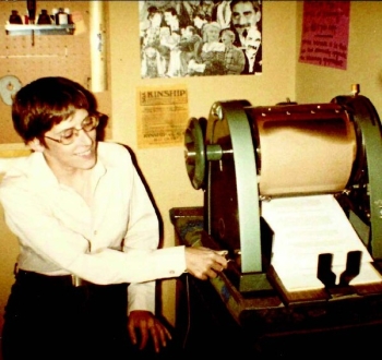 Old photo of a woman operating a printing press