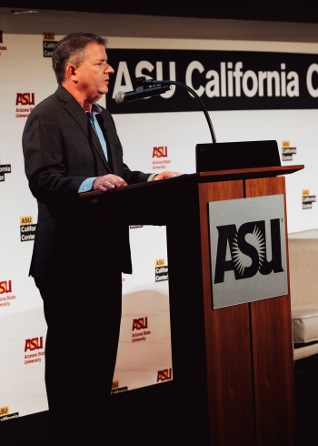 Man in suit speaking at lectern