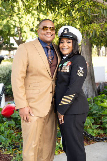 Tanisha Smith, in dress uniform, stands with her husband outside.