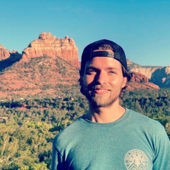 Portrait of Wade Sharp standing in a desert landscape.