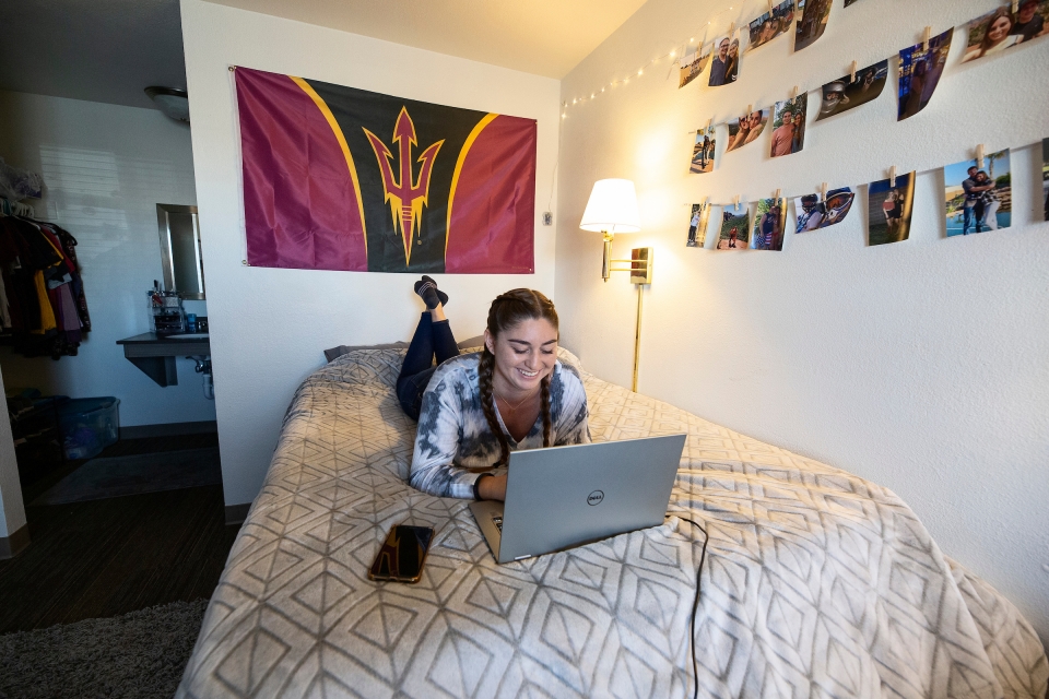 Student works on a laptop in a dorm room