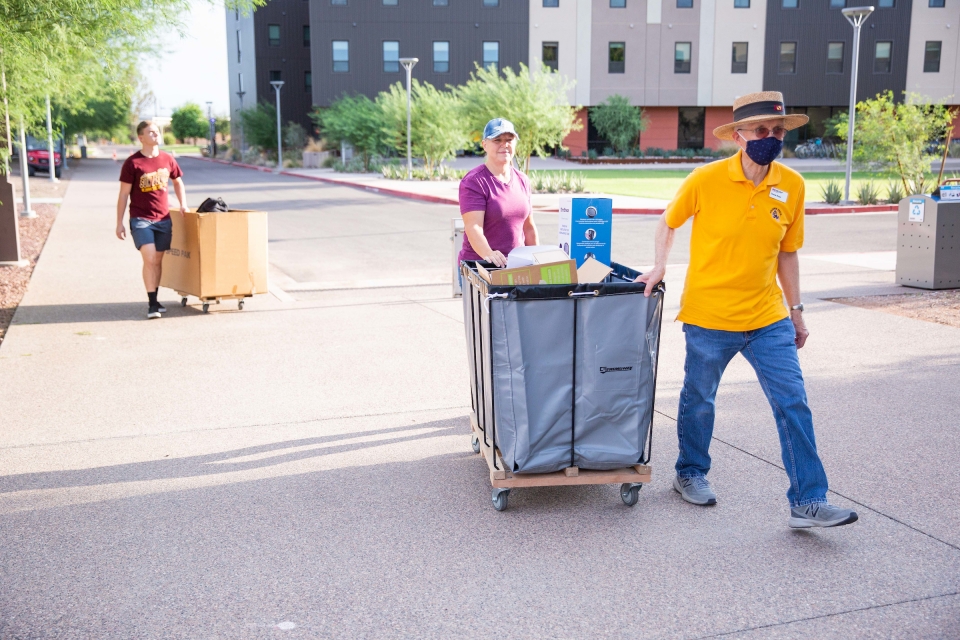 people pushing bins during move-in