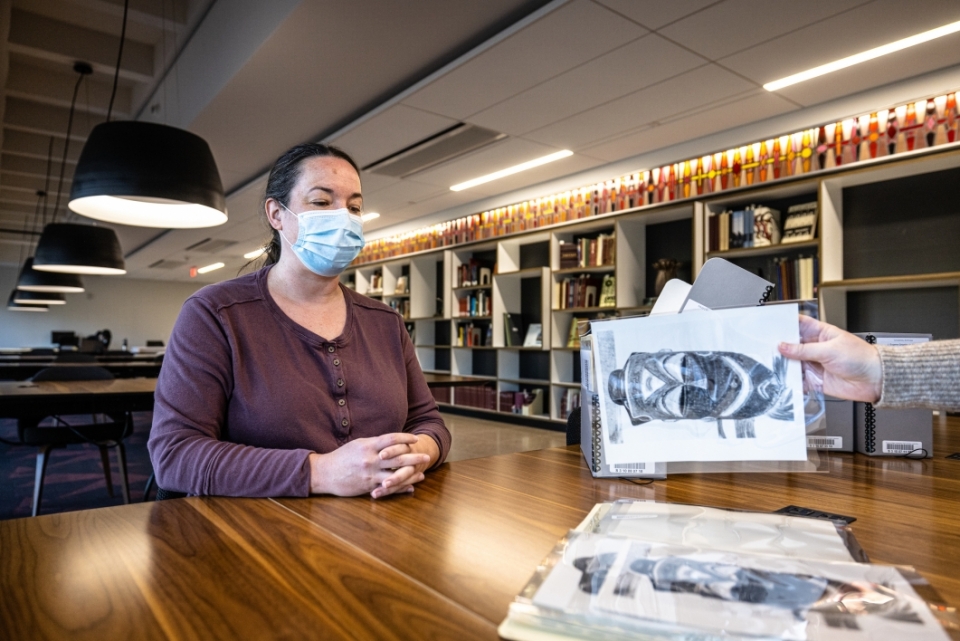 ASU Library Associate Archivist Elizabeth Dunham looks at photos of African and Indigenous masks from the J. Eugene Grigsby Jr. Papers collection.
