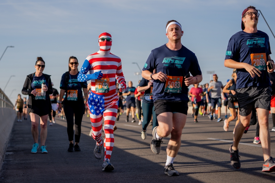 Racers, including a man wearing a full American flag outfit, run in Tempe