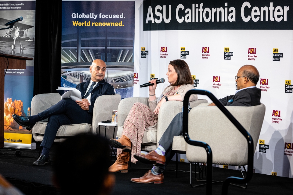 Two men and a woman sit on a stage with mics and a sign behind them that says ASU California Center