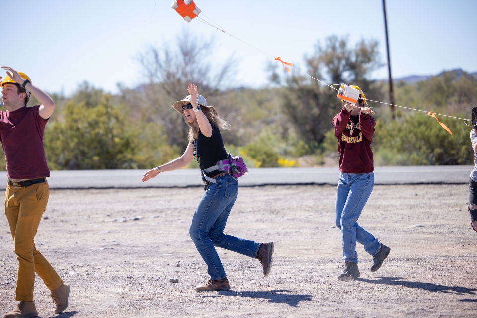 Students hold up the payload tethered to the balloon as it launches