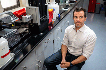 ASU Associate Professor Benjamin Trumble seated in a lab.