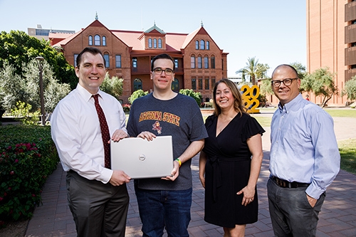 Four people stand in front of Old Main on ASU's Tempe campus.