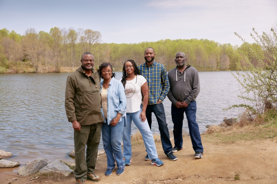 Family posing in front of river