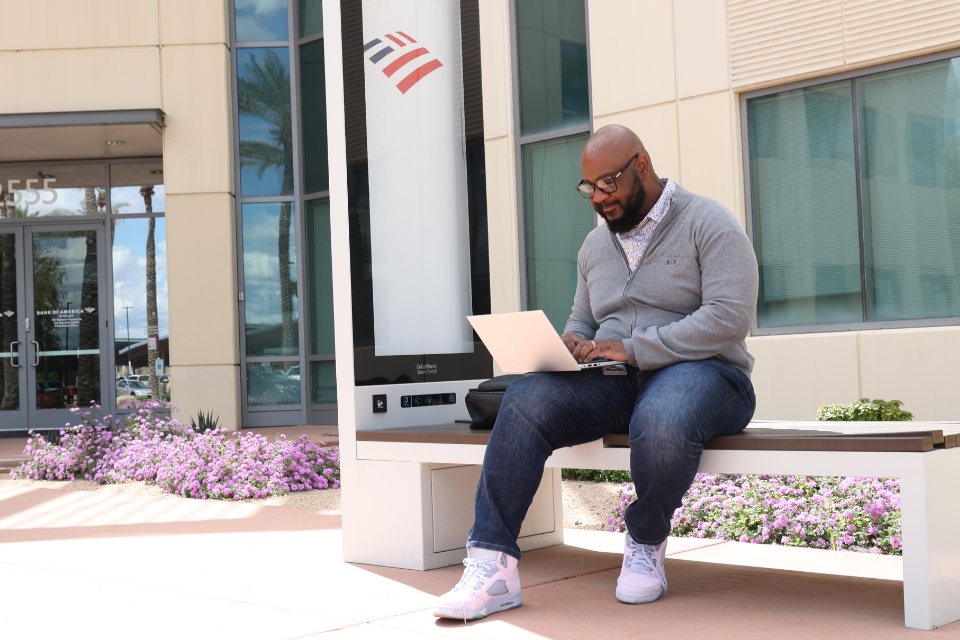 Man sitting on bench outside Bank of America office