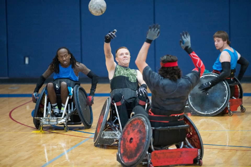 men using wheelchairs while playing rugby