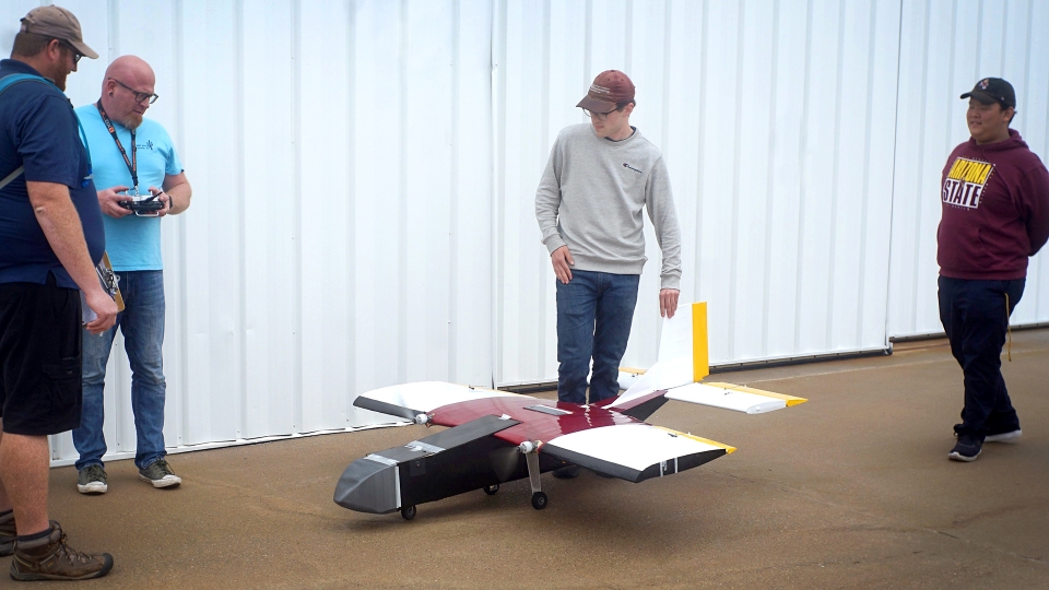 Air Devils inspect their unmanned, remote-controlled aircraft before flight.