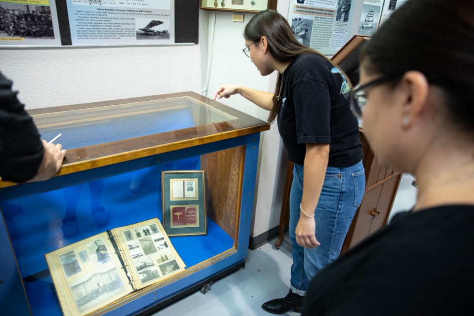 People looking in museum case at artifacts