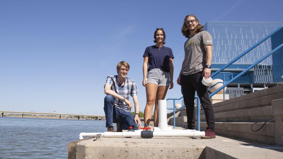 three people posing next to lakefront