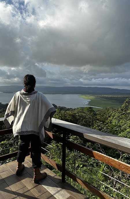 A young man looks out over a Costa Rica lake from a viewing platform