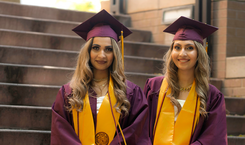 Two sisters in graduation caps and gowns