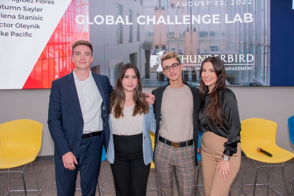 Group of people pose for a photo in front of a sign that reads "Global Challenge Lab."