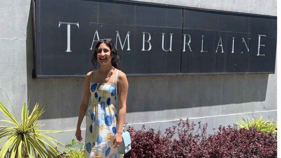 ASU student Anna Montoya smiling and standing in front of a sign that reads "Tamburlaine."ourtesy Anna Montoya