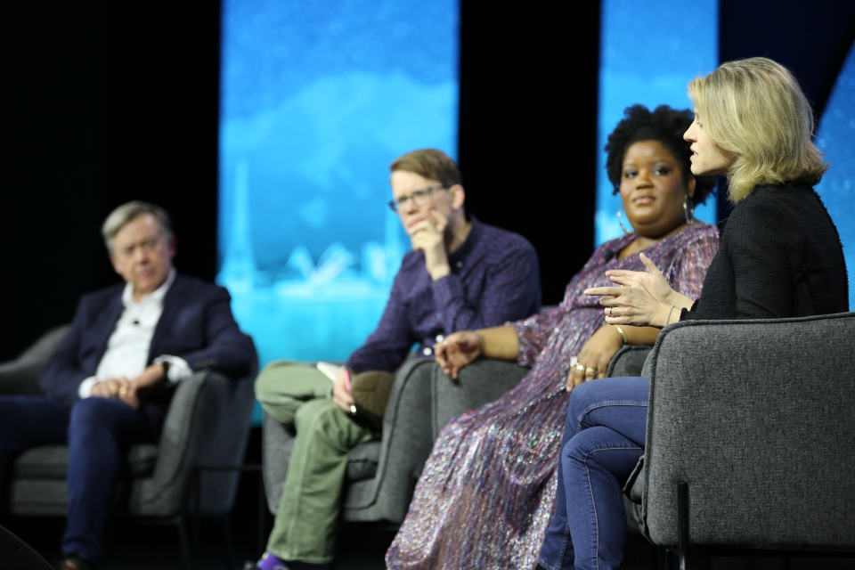 Four people sitting on stage for panel discussion