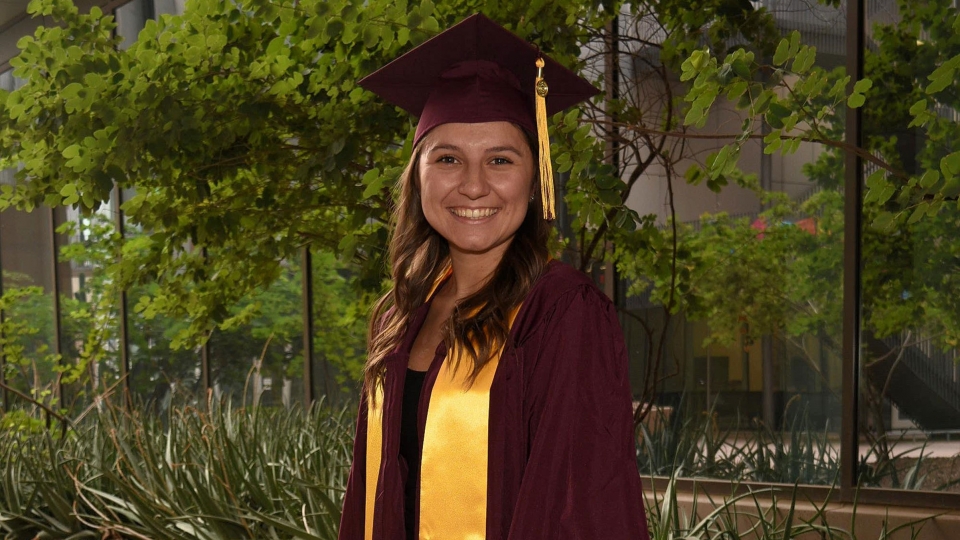 Honors graduate Sarah Lopez poses for a photo in her graduation cap and gown