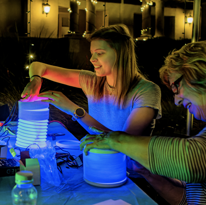 People during a workshop building an LED lantern