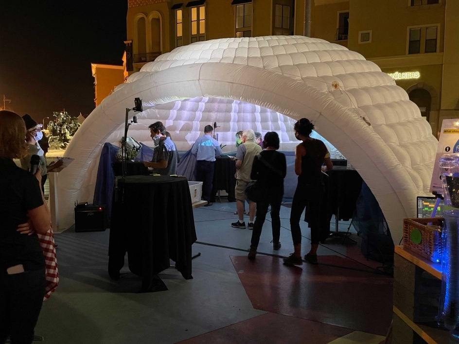People standing under an interactive dome tasting waters