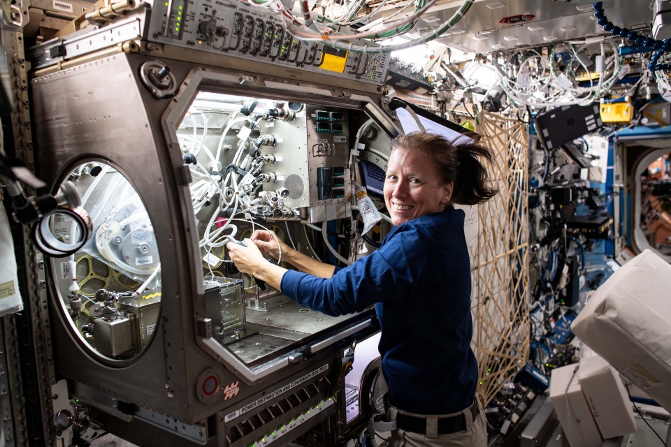 Astronaut working with machinery in space.