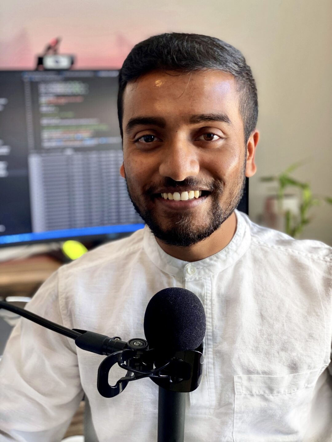 Portrait of ASU computer science doctoral student and researcher Jay Shah with a microphone.