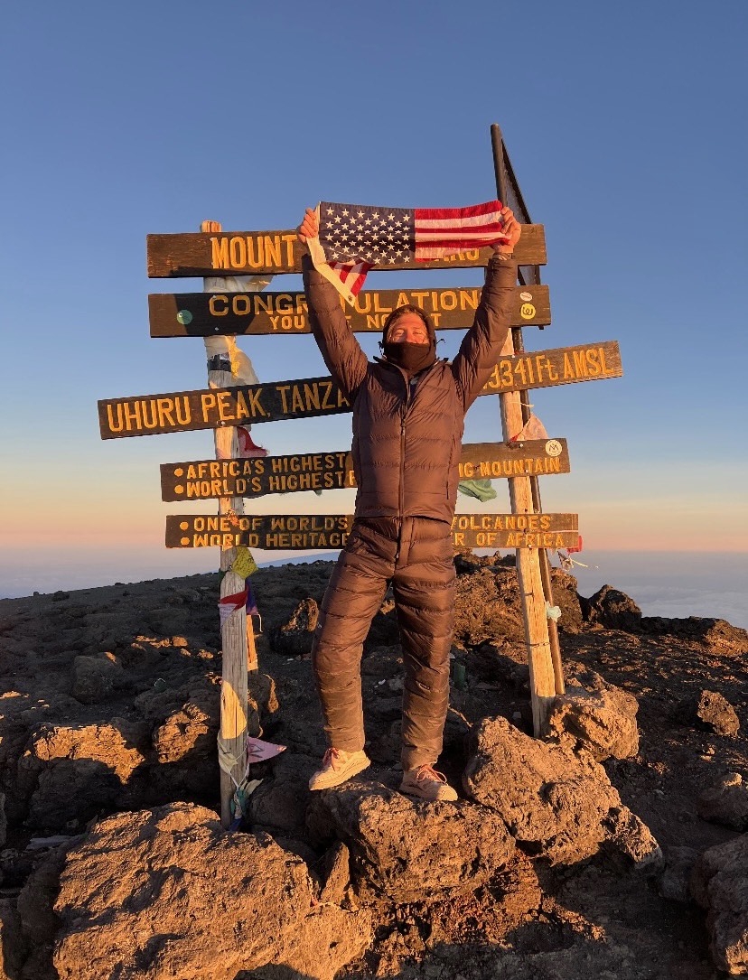 Man holding up flag on mountain