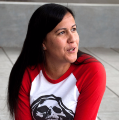 Portrait of woman with long dark hair wearing a baseball style tee