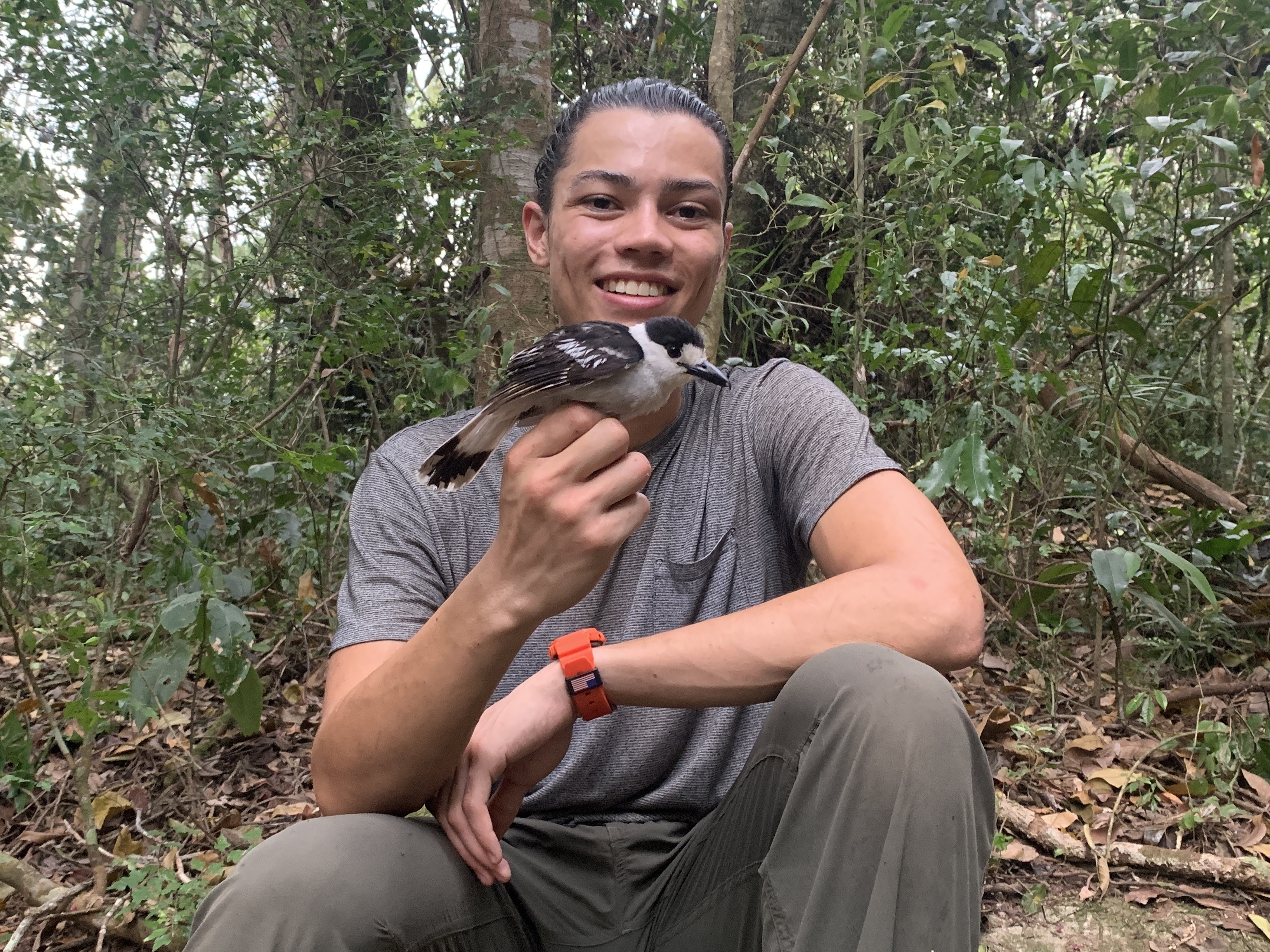 Tahiry Langrand, ancien élève de l'ASU, tenant un oiseau dans la forêt