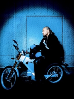 Jean Dawson sitting on a motorcycle under blue light