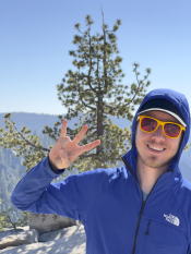Selfie shot of Jacob Stillwell doing the forks up hand sign in an outdoor setting