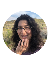 Portrait of a woman wearing glasses with long curly dark hair 