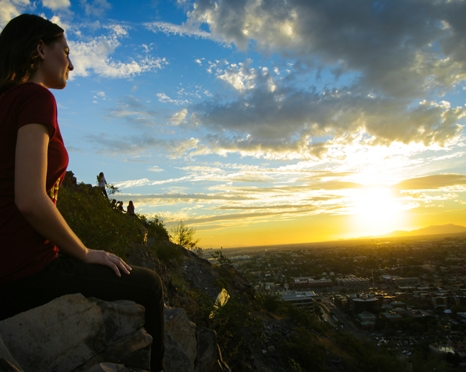 woman on mountain looking at sunset