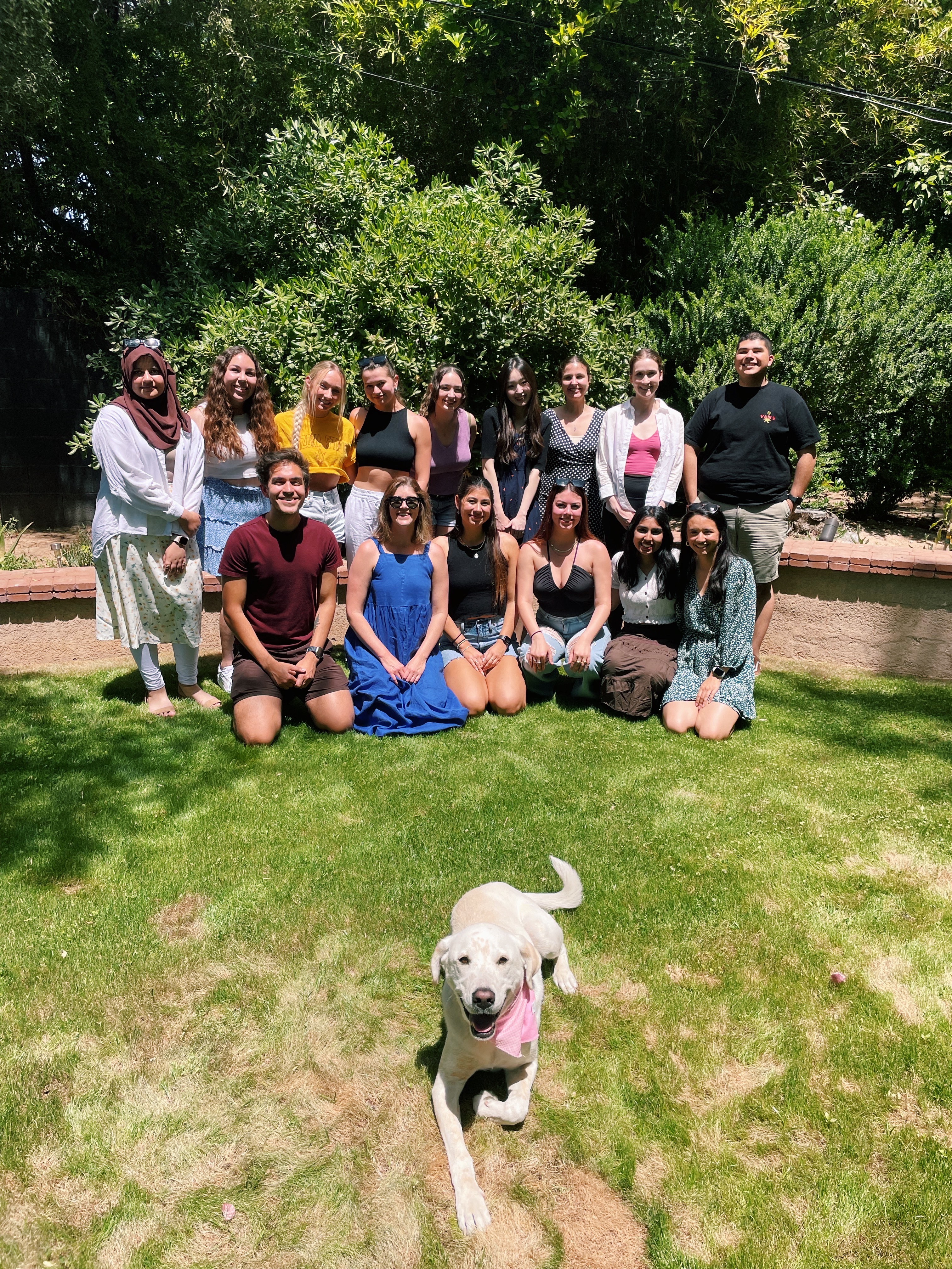 Members of Dr. Kelsey Lucca’s Emerging Minds Lab pose for a group photo behind Dr. Lucca’s dog, Homer. Homer has been affectionately coined the lab’s “paw-assistant.”