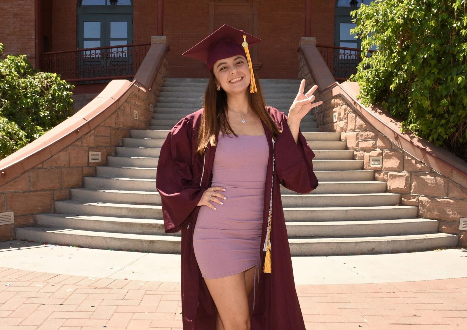 Outstanding Graduate  standing in front of Old Main at ASU