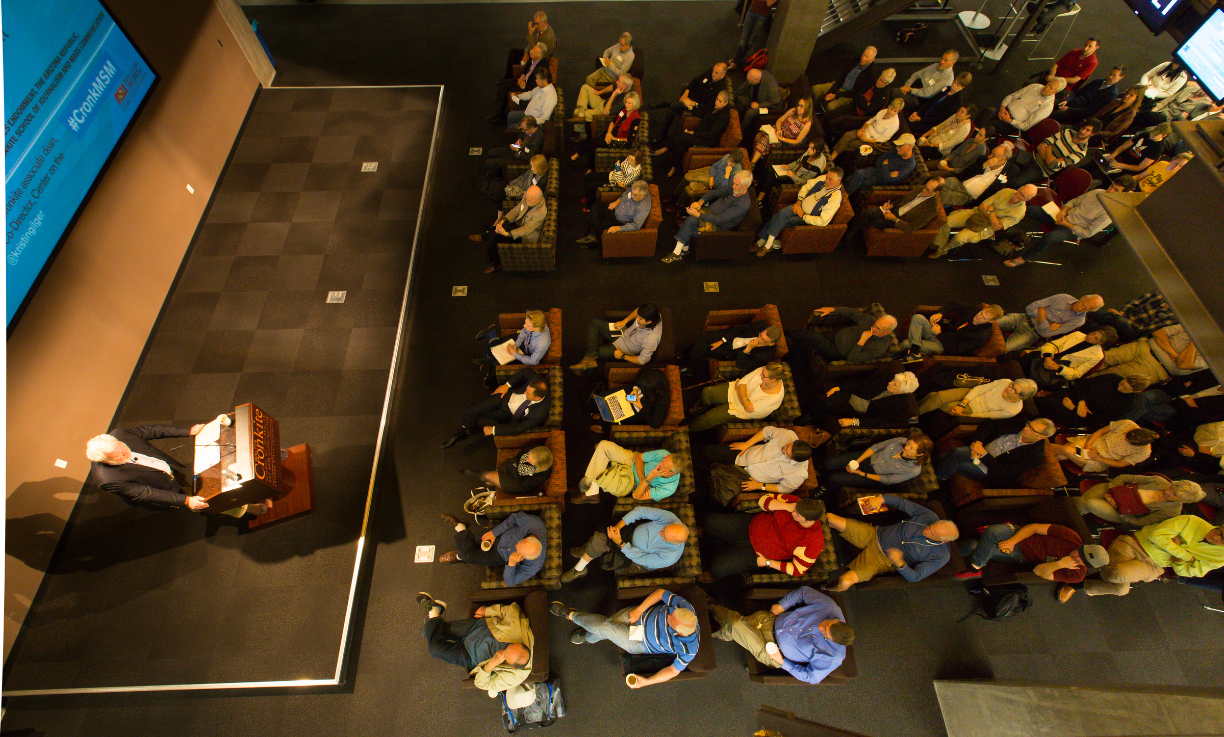 An aerial photo of a crowd listening to a speaker inside the Cronkite School.