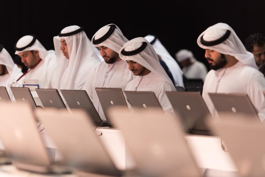 UAE men stand at a line of laptops