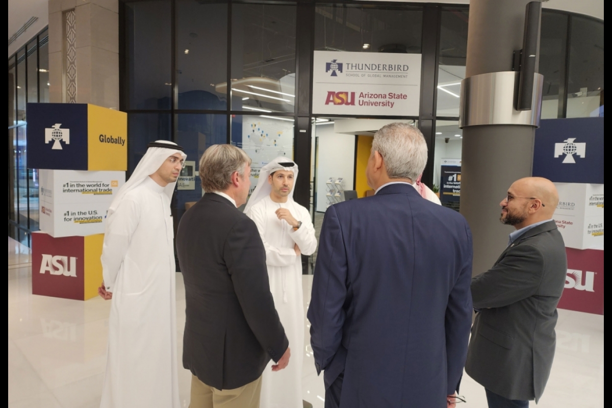 A group of men speak outside an ASU Thunderbird center